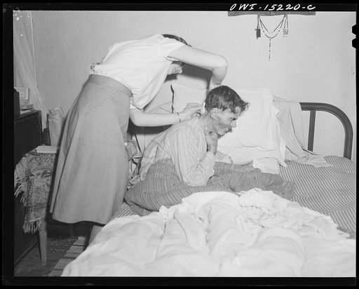 Llano Quemado (vicinity), New Mexico. Marjorie Muller, nurse from the clinic operated by the Taos County cooperative health association, giving treatment on a home call