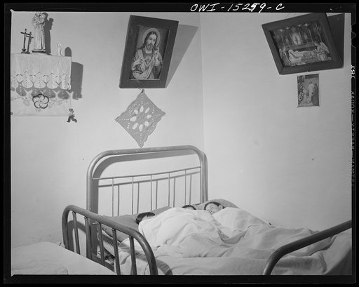 Trampas, New Mexico. In many Spanish-American homes, mattresses are rolled out on the floor at night. But by putting three under a blanket the Lopez family all sleep in beds