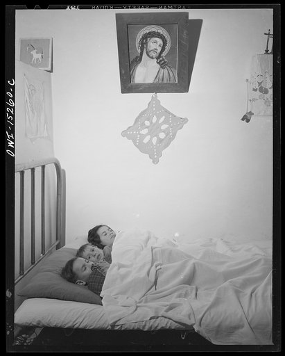Trampas, New Mexico. In many Spanish-American homes, mattresses are rolled out on the floor at night. But by putting three under a blanket the Lopez family all sleep in beds