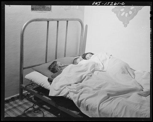 Trampas, New Mexico. In many Spanish-American homes, mattresses are rolled out on the floor at night. But by putting three under a blanket the Lopez family all sleep in beds