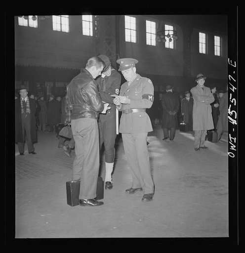 Chicago, Illinois. Military and Naval police help a recruit on his way at the Union Station