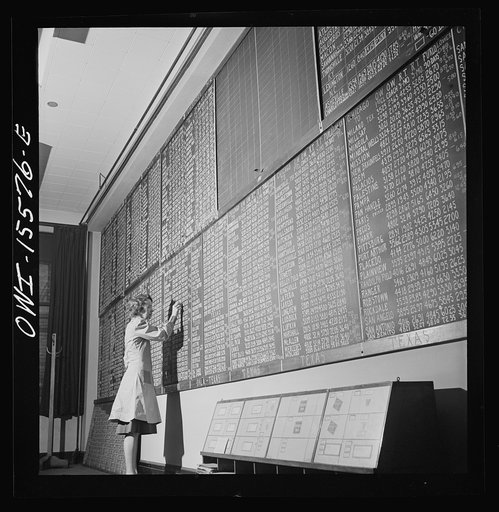 Chicago, Illinois. Mrs. Marie Griffith, manager of the information room, at one of the boards listing rates to points all over the country at the Union Station
