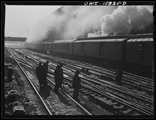 Untitled photo, possibly related to: Chicago, Illinois. A double-header pulls out of the Union Station as a section crew watches