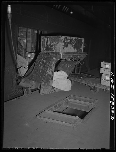 Chicago, Illinois. A mail-unloader in operation at Union Station. It extends a moving belt into the car onto which the mail bags are dumped, carried out of the car over to these open trap doors in the railroad platform. Under the trap doors is another conveyor belt running the length of the platform