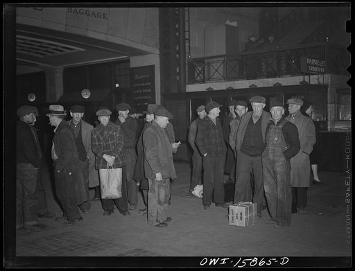 Chicago, Illinois. Workmen waiting for a suburban train at the Union Station