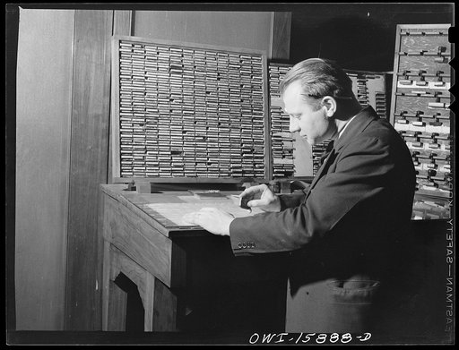 Chicago, Illinois. Ticket seller making out a ticket for a passenger at the Union Station. On the panel are rubber stamps of the most frequent destinations. Other stations are written in on the ticket