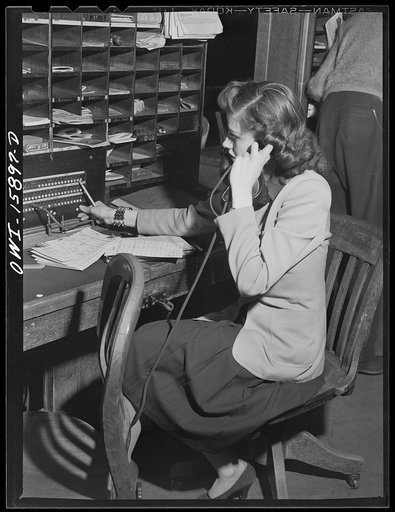 Chicago, Illinois. In the reservation bureau at the Union Station. The reservation diagrams on the shelves are within easy reach of the girls on both sides of the cubbyholes