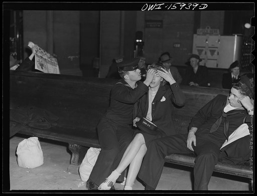 Chicago, Illinois. Sailor helping his girlfriend fix her hair at Union Station