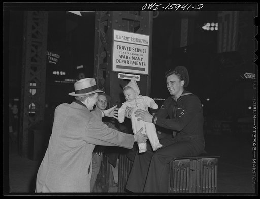 Chicago, Illinois. Sailor playing with a baby on the train concourse of the Union Station