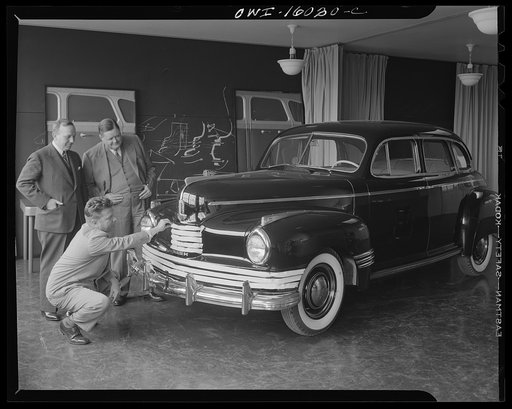 Detroit, Michigan. Norman Bel Geddes and Nash-Kelvinator corporation officials inspecting a marked-up model of a new car