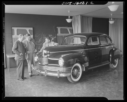Untitled photo, possibly related to: Detroit, Michigan. Norman Bel Geddes and Nash-Kelvinator corporation officials inspecting a marked-up model of a new car