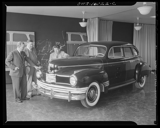 Untitled photo, possibly related to: Detroit, Michigan. Norman Bel Geddes and Nash-Kelvinator corporation officials inspecting a marked-up model of a new car