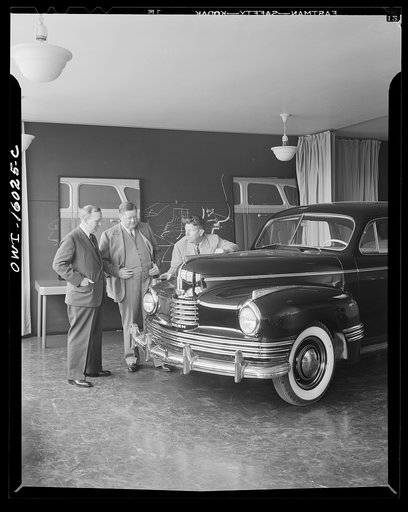 Untitled photo, possibly related to: Detroit, Michigan. Norman Bel Geddes and Nash-Kelvinator corporation officials inspecting a marked-up model of a new car