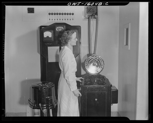 Detroit, Michigan. New method of making x-ray photographs size 4x5 inches instead of larger, used at the Herman Kiefer Hospital for Communicable Diseases to show various stages of tuberculosis. X-ray operator with an electrical tube in use. This room is lined with lead and the operator looks through