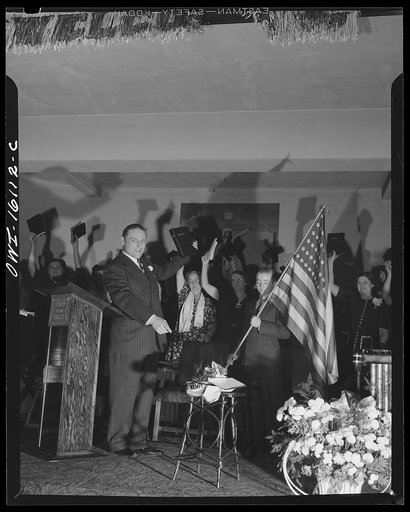Untitled photo, possibly related to: Toledo, Ohio. Evangelical church ceremony at which the preacher delivered a hysterical speech, and then burned a copy of Hitler's Mein Kampf. Preacher with the Bible, Mein Kampf burning, and a boy with the American flag