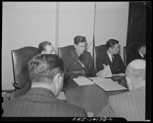 Untitled photo, possibly related to: Detroit, Michigan. Conference between U.S. Army ordnance and washing machine industry officials to determine the ability of manufacturers to produce parts needed by the Army. After inspecting samples, blueprints and prices were discussed