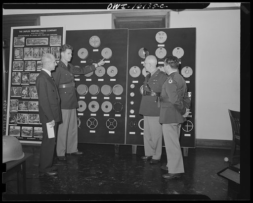 Detroit, Michigan. Conference between U.S. Army ordnance and washing machine industry officials to determine the ability of manufacturers to produce parts needed by the Army. After inspecting samples, blueprints and prices were discussed. Parts of land mine