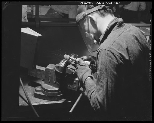 Detroit, Michigan. A box for suggestions from workers installed in the Cadillac motor ar division of General Motors Corporation (?) with a jig holding two parts in a vise. A worker suggested the design for a jig to hold six of these parts at once, and so cut down handling time