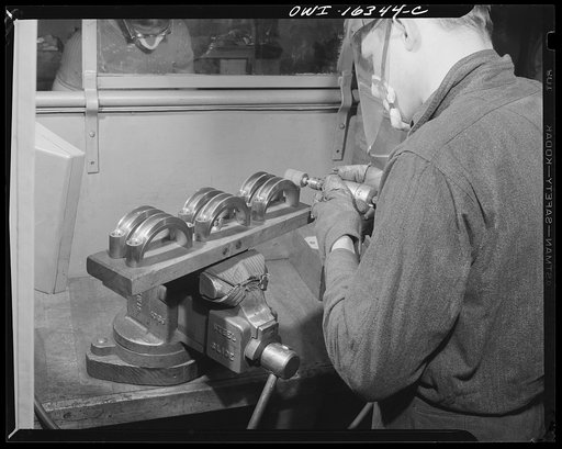 Detroit, Michigan. An operation at the Cadillac motor car division of General Motors Corporation (?) showing a jig for holding six parts instead of two, as suggested by a worker so as to reduce handling time