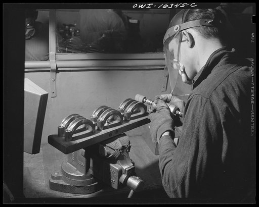 Detroit, Michigan. An operation at the Cadillac motor car division of General Motors Corporation (?) showing a jig for holding six parts instead of two, as suggested by a worker so as to reduce handling time