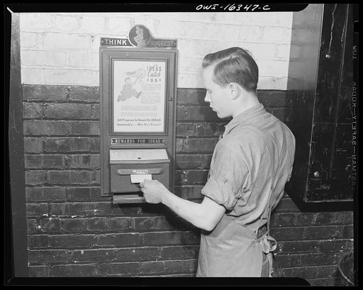 Detroit, Michigan. A box for suggestions from workers installed in the Cadillac motor car division of General Motors Corporation (?). Worker and suggestion box
