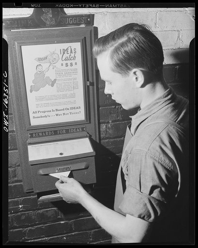 Detroit, Michigan. A box for suggestions from workers installed in the Cadillac motor car division of General Motors Corporation (?). Worker with suggestion box