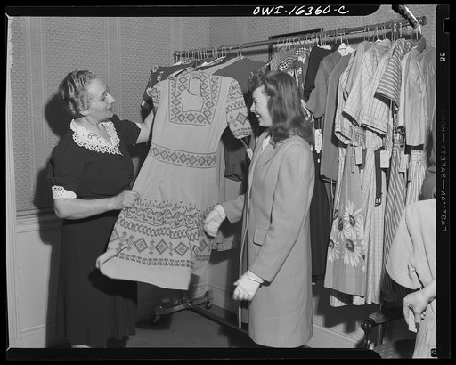 Detroit, Michigan. Girl and sales lady examining a dress at Saks Fifth Avenue store following a fashion show presented by the Chrysler Girls' Club of the Chrysler Corporation