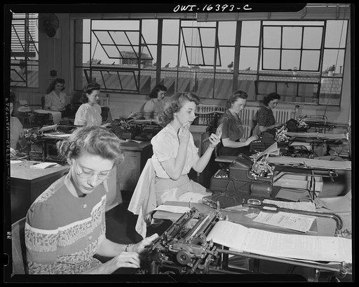 Detroit, Michigan. Office workers at work (one powdering her chin) at the Chrysler Corporation