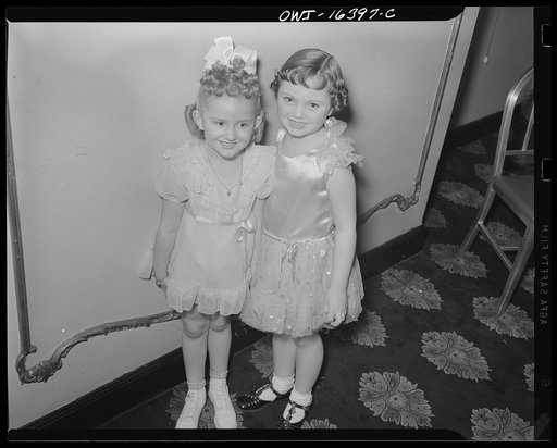 Detroit, Michigan. Two little girls in their party dresses at a hair styling show
