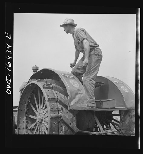 Untitled photo, possibly related to: Jackson, Michigan. Tractor which runs a threshing machine