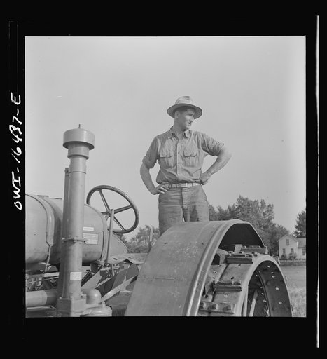 Untitled photo, possibly related to: Jackson, Michigan. Soldier, who was granted a furlough to help with the harvesting on this farm, watching threshing