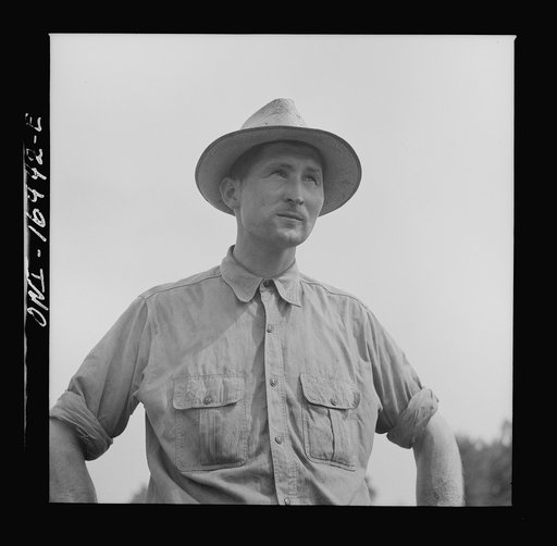 Jackson, Michigan. Soldier, who was granted a furlough to help with the harvesting on this farm, watching threshing