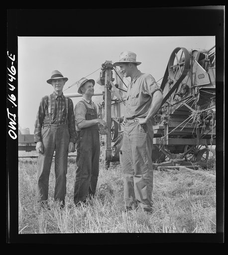 Untitled photo, possibly related to: Jackson, Michigan. Soldier who was granted a furlough to help with the harvesting on this farm, and farmer watching the threshing