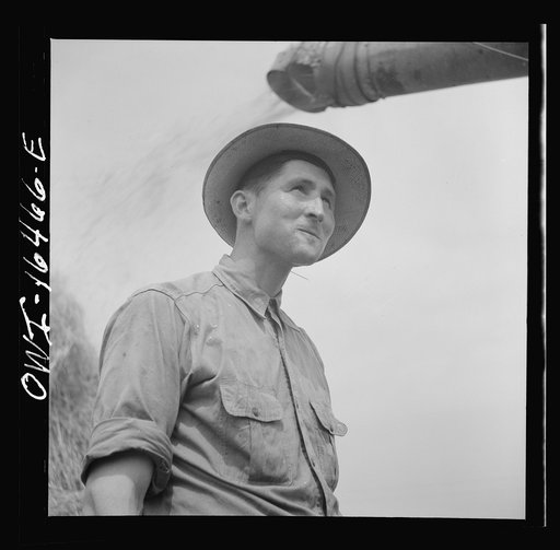 Untitled photo, possibly related to: Jackson, Michigan. Soldier, who was granted a furlough to help with the harvesting on this farm, watching threshing