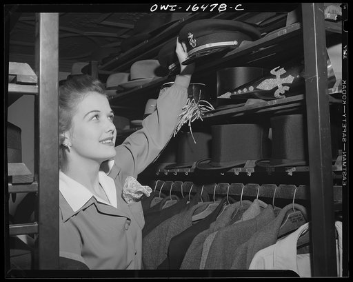 Detroit, Michigan. Hat check girl with officers' headgear and formal hats on New Year's Eve