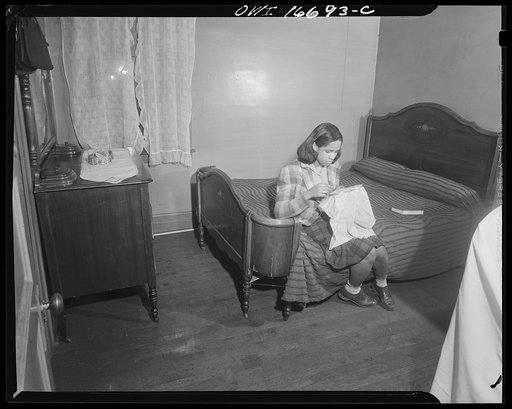 Detroit, Michigan. Negro doing embroidery work in her bedroom. These are conditions under which families originally lived before moving to the Sojourner Truth housing project