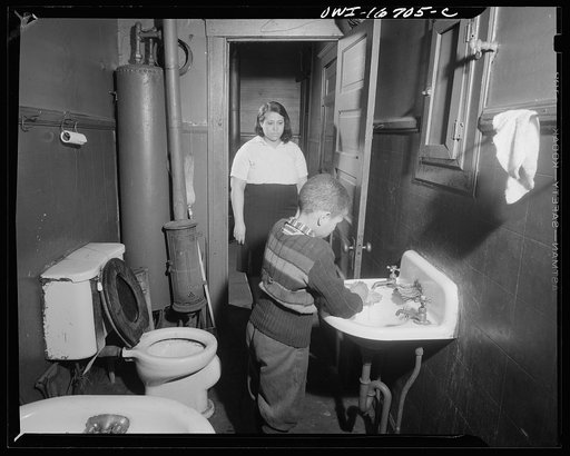 Detroit, Michigan. Interior of a bathroom, with a Negro boy washing his hands. These are conditions under which families originally lived before moving to the Sojourner Truth housing project
