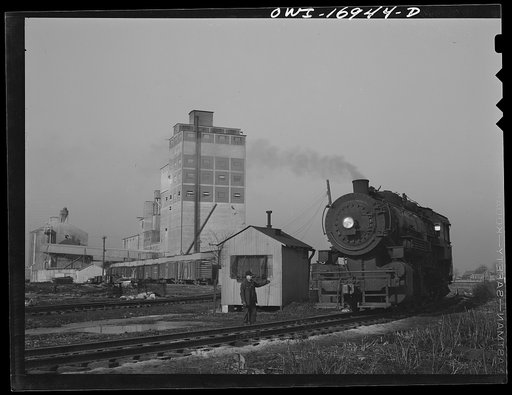 Blue Island, Illinois. Daniel Senise at his job at an Indiana Harbor Belt Line railroad yard. In the background is the Arcady Milling Company to which he makes many deliveries