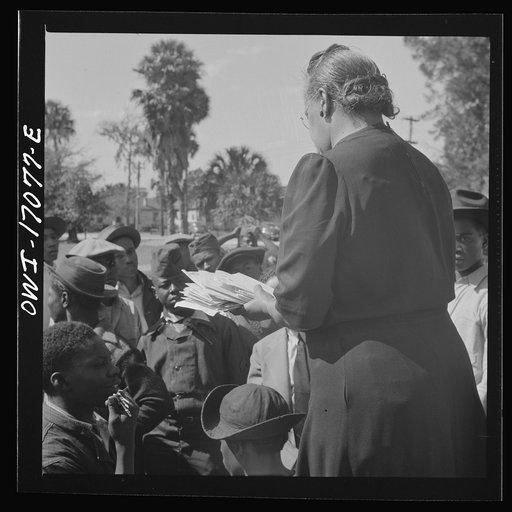 Untitled photo, possibly related to: Daytona Beach, Florida. Bethune-Cookman College. Mrs. Shaw handing out mail to college and NYA (National Youth Administration) students in front of the boys' dormitory