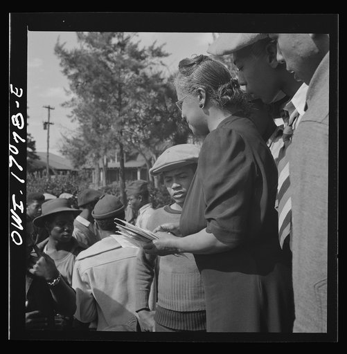 Untitled photo, possibly related to: Daytona Beach, Florida. Bethune-Cookman College. Mrs. Shaw handing out mail to college and NYA (National Youth Administration) students in front of the boys' dormitory