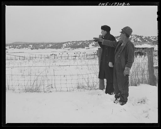 Taos County, New Mexico. Father Cassidy, the Catholic priest of the parish of Penasco, helping to appraise a parishioner's land