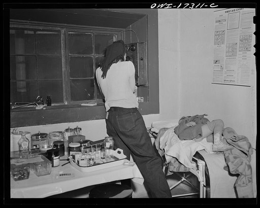 Penasco, New Mexico. The nurse from the clinic telephoning the hospital in Taos to prepare the operating room for a little girl who is dying from appendicitis