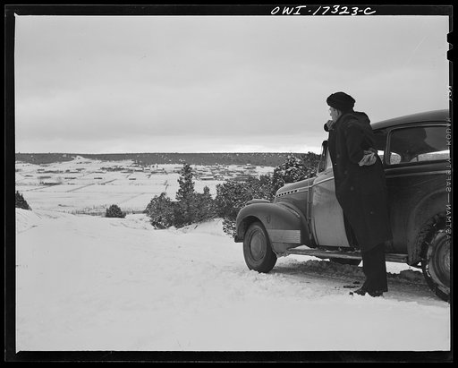 Taos County, New Mexico. Father Cassidy, the Catholic priest of the parish of Penasco, coming into the village of Chamisal