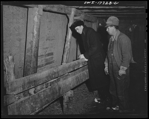 Taos County, New Mexico. Father Cassidy, the Catholic priest of the parish of Penasco, inspecting a parishioner's property so he may be able to advise him
