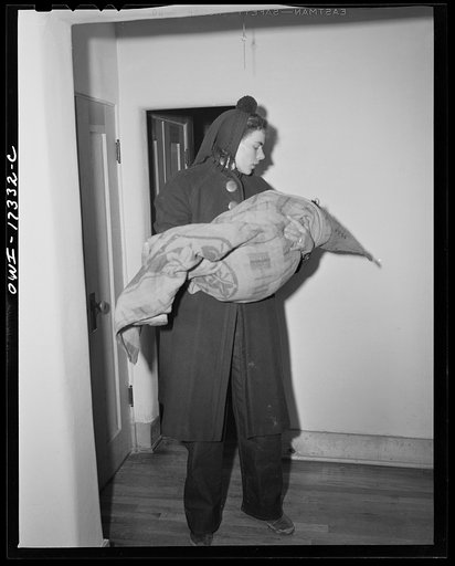 Taos, New Mexico. Nurse from Penasco carrying a little girl dying of appendicitis into the Holy Cross Hospital