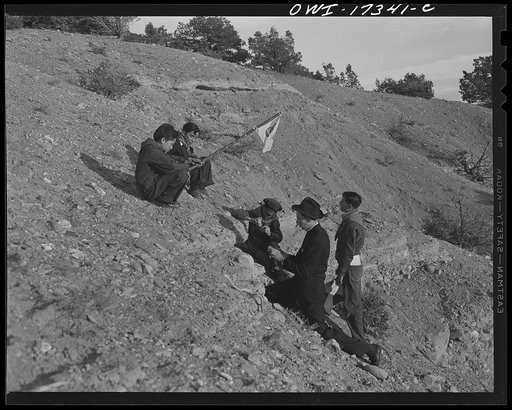 Taos County, New Mexico. Father Cassidy, the Catholic priest of the parish of Penasco, telling his troop of Boy Scouts about the science of geology