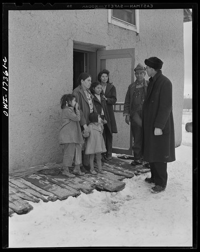 Taos County, New Mexico. Father Cassidy, the Catholic priest of the parish of Penasco, bidding goodbye to a family in his parish