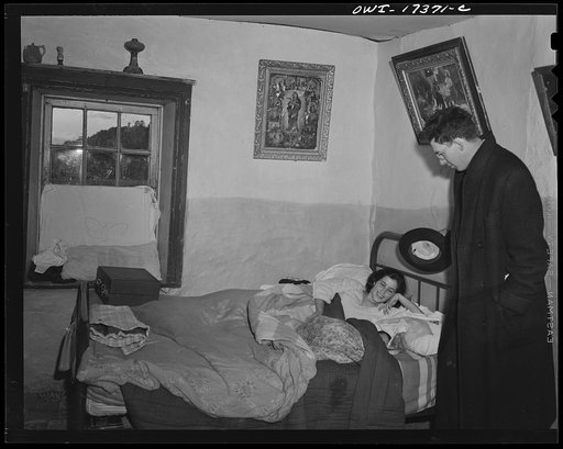 Taos County, New Mexico. Father Cassidy, the Catholic priest of the parish of Penasco, visiting a mother and her new baby