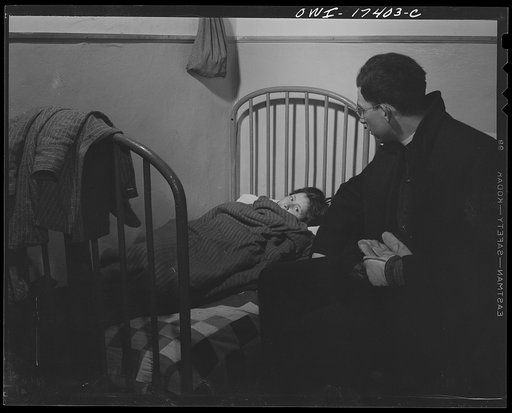 Taos County, New Mexico. Father Cassidy, the Catholic priest of the parish of Penasco, visiting a sick child