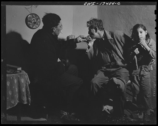 Taos County, New Mexico. Father Cassidy, the Catholic priest of the parish of Penasco, smoking and talking things over with a parishioner